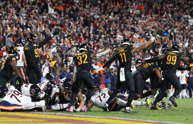 Commanders players make a turnover gesture after causing a Bears fumble at the goal line in the fourth quarter at Northwest Stadium on Oct. 27, 2024, in Landover, Maryland. (John J. Kim/Chicago Tribune)