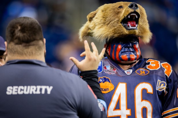 A bears fan talks to security as players warm up before the Bears play against the Lions at Ford Field in Detroit on Nov. 28, 2024. (Tess Crowley/Chicago Tribune)