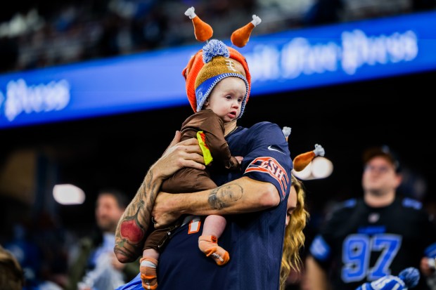 A Bears fan holds a Lions fan before the Bears play against the Lions at Ford Field in Detroit on Nov. 28, 2024. (Tess Crowley/Chicago Tribune)