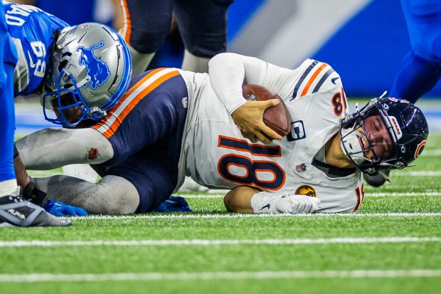 Bears quarterback Caleb Williams (18) is sacked by Lions linebacker Al-Quadin Muhammad (69) during the fourth quarter in a game against the Lions at Ford Field in Detroit on Nov. 28, 2024. The Bears lost 23-20. (Tess Crowley/Chicago Tribune)