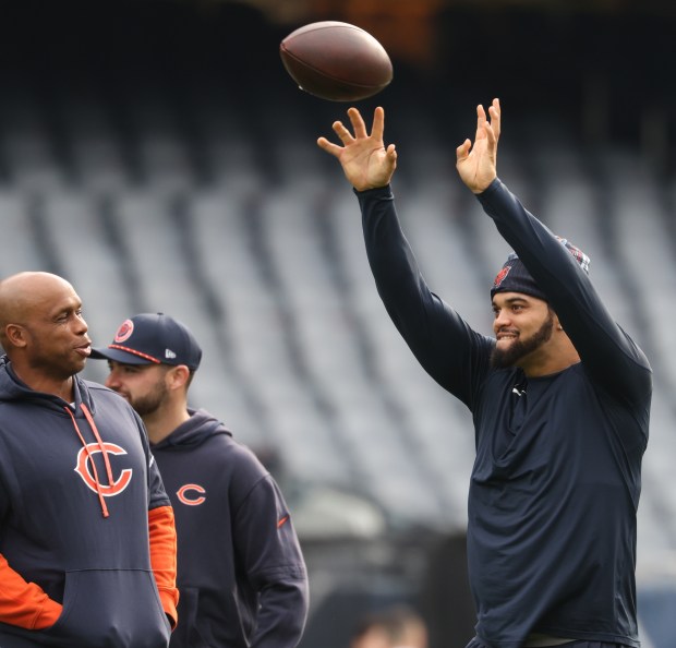 Bears quarterbacks coach Kerry Joseph, left, watches as quarterback Caleb Williams warms up for a game against the Packers. (John J. Kim/Chicago Tribune)