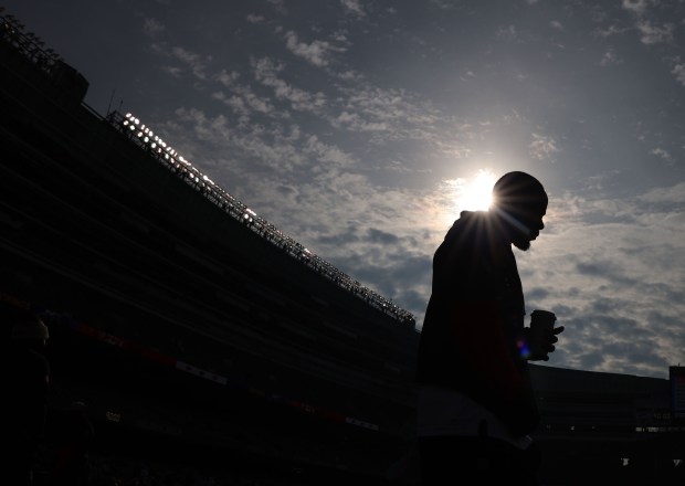 Chicago Bears offenseive coordinator Thomas Brown walks the perimeter of the field with a beverage before the start of the game. (Stacey Wescott/ Chicago Tribune)