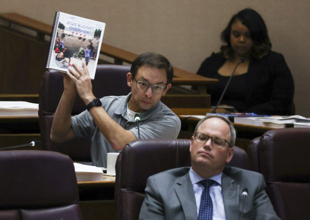 Ald. Raymond Lopez, 15th, holds up the budget overview booklet when he asks a question during the first day of the 2025 budget hearing at City Hall on Nov. 6, 2024. (Eileen T. Meslar/Chicago Tribune)