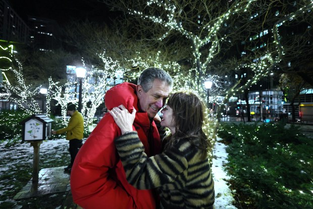 Marc Schulman and wife, Maureen Schulman, embrace during a holiday tree lighting ceremony at Seneca Park in Chicago, Nov. 21, 2024. Marc Schulman is chairman of the Seneca Park & Eli M. Schulman Playground Advisory Council. (Terrence Antonio James/Chicago Tribune)