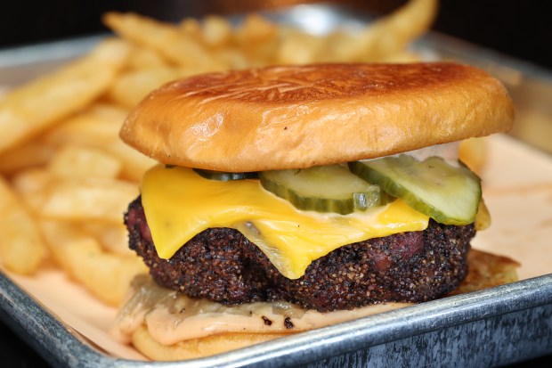 A smoked cheeseburger with fries is served at Sanders BBQ Supply Co. on West 99th Street in Chicago, Nov. 21, 2024. (Terrence Antonio James/Chicago Tribune)