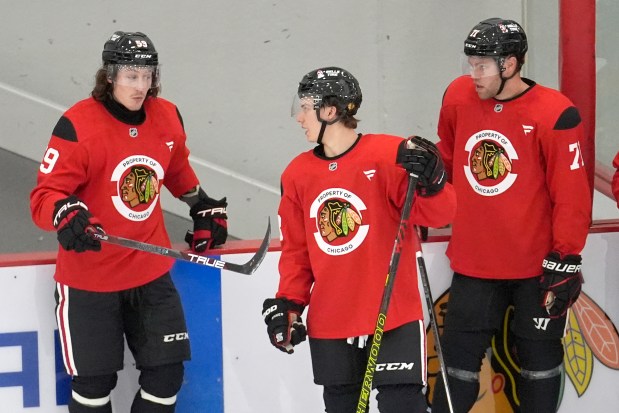 The Blackhawks' Tyler Bertuzzi, left, talks with Connor Bedard, center, and Taylor Hall during training camp on Sept. 19, 2024. (AP Photo/Charles Rex Arbogast)