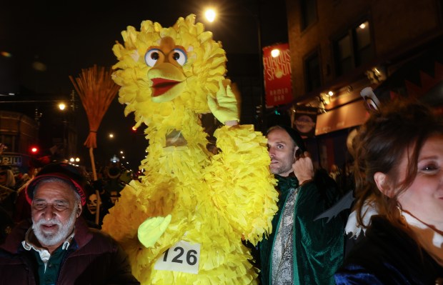 A person dressed as Big Bird waits to march with others at the Haunted Halsted Halloween Parade in the 3200 block of North Halsted Street, Oct. 31, 2024, in Chicago. (John J. Kim/Chicago Tribune)