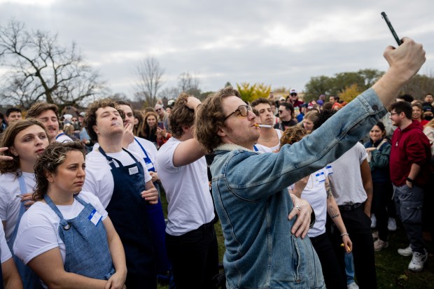 Alex Short takes a photo with fellow participants in a Jeremy Allen White lookalike competition at Humboldt Park in Chicago on Nov. 16, 2024. (Tess Crowley/Chicago Tribune)