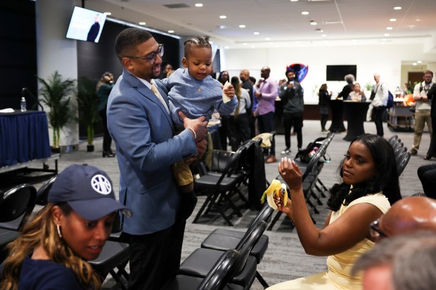 Sky coach Tyler Marsh holds his son, Jaxxon, as his wife, Kiara, sits nearby after a news conference at Wintrust Arena on Nov. 12, 2024. (Eileen T. Meslar/Chicago Tribune)