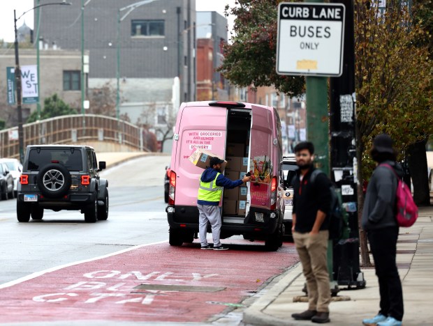 A delivery van parks in a bus lane near a news conference at Chicago and Milwaukee avenues, Nov. 4, 2024, for a pilot program called Smart Streets. The system will send drivers parked in bike and bus lanes warnings and, soon, tickets in the mail. (Antonio Perez/Chicago Tribune)