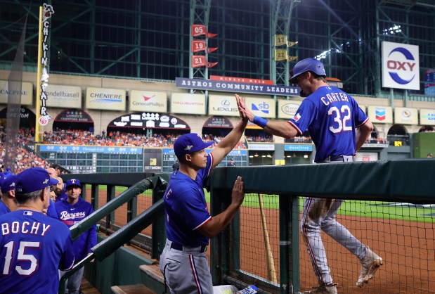 The Rangers' Evan Carter is congratulated by Will Venable after Carter scored in the second inning against the Astros during Game 1 of the American League Championship Series at Minute Maid Park on Oct. 15, 2023 in Houston. (Carmen Mandato/Getty Images)