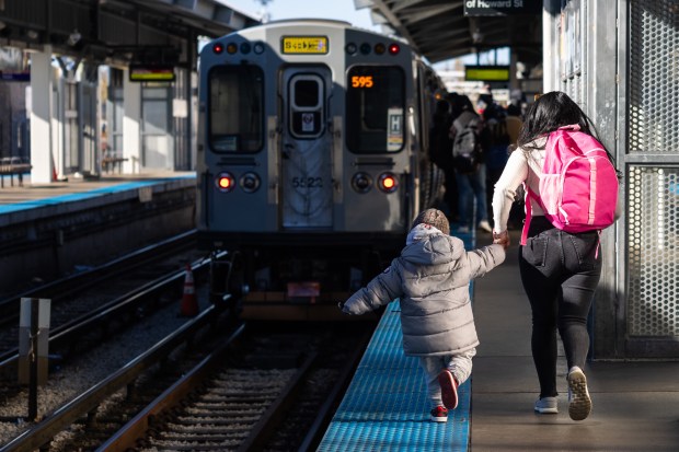 People run to catch the CTA's Yellow Line "L" train after it arrives at the Howard Street station in Chicago's Rogers Park neighborhood on Nov. 1, 2024. (Tess Crowley/Chicago Tribune)