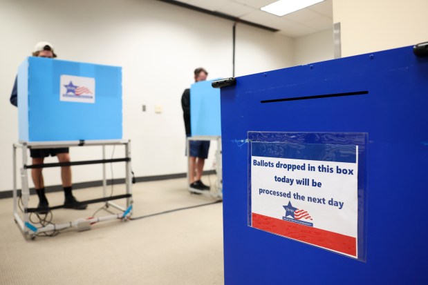 People vote near a ballot drop-off box at the Goldblatt's Building in West Town on Oct. 28, 2024, during the early voting period. (Eileen T. Meslar/Chicago Tribune)