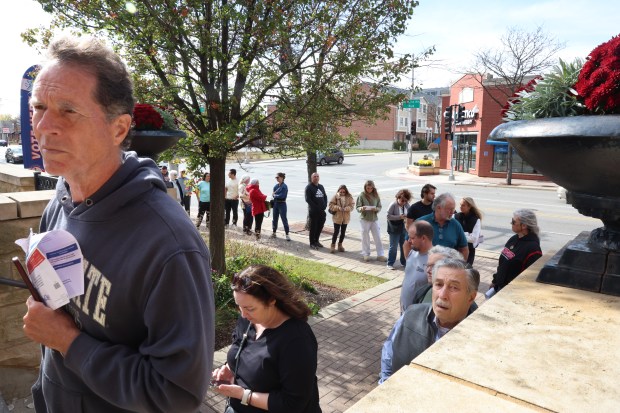 People line up outside the Arlington Heights Village Hall to vote early on Oct. 28, 2024. (Stacey Wescott/Chicago Tribune)