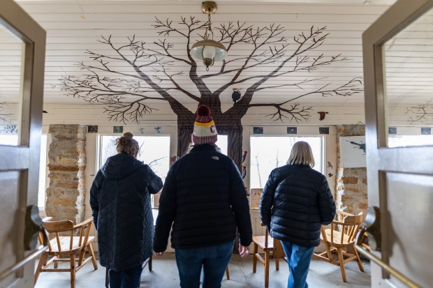 Cathy Sander, left, Carrie Werner, center, and Patti Nishimura walk through Poley Cottage on Lorado Taft's campus during an open house in Oregon, Illinois on Nov. 10, 2024. (Troy Stolt/for the Chicago Tribune)