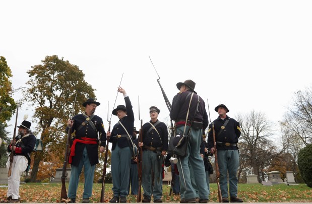 Members of the 1st Michigan Engineers Company E reenactment group handle their rifle muskets before a Veterans Day observance and ceremony at Rosehill Cemetery on Saturday, Nov. 9, 2024. (John J. Kim/Chicago Tribune)