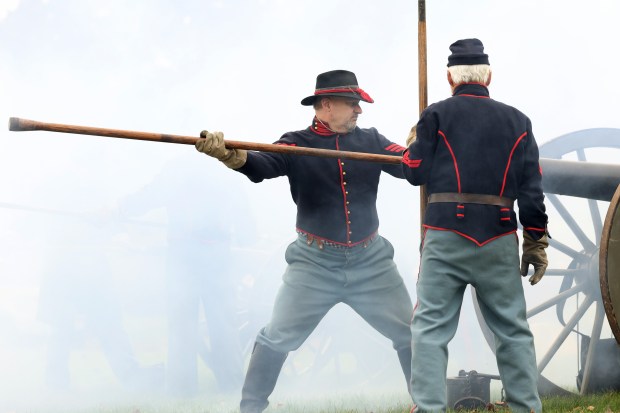 Cannon gun smoke surrounds members of the Chicago Light Artillery Battery A and B reenactment groups in a salute during a Veterans Day observance and ceremony. (John J. Kim/Chicago Tribune)