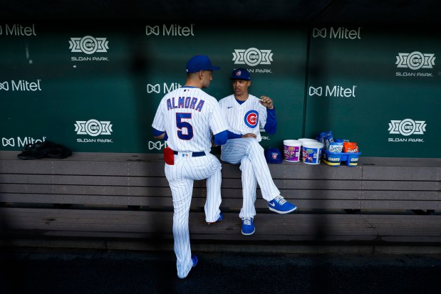 Cubs center fielder Albert Almora Jr. talks with third base coach Will Venable in the dugout before a spring training game at Sloan Park in Mesa, Ariz. on Feb. 22, 2020. (Jose M. Osorio / Chicago Tribune)