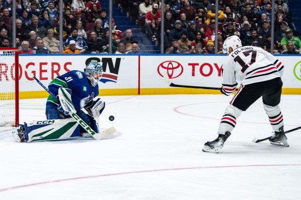 Vancouver Canucks goaltender Arturs Silovs (31) stops Chicago Blackhawks' Nick Foligno (17) during the second period of an NHL hockey game in Vancouver, British Columbia, Saturday, Nov. 16, 2024. (Ethan Cairns/The Canadian Press via AP)