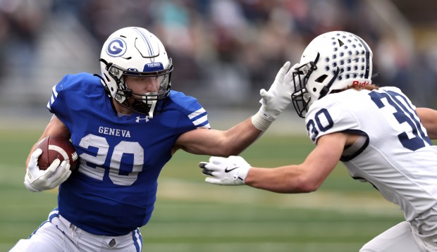 Geneva's Michael Rumoro (20) stiff arms Cary-Grove's Landon Moore for a 13-yard gain in the quarter quarter during a Class 6A state semifinal on Nov. 23, 2024, in Geneva. (H. Rick Bamman/The Beacon-News)