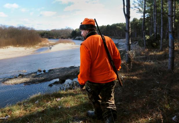 FILE - In this Nov. 19, 2016 file photo, Greg Boley takes in a view of the Eau Claire River before heading back out into the woods during the gun deer hunt season opener on public land in Fall Creek, Wis. (Marisa Wojcik/The Eau Claire Leader-Telegram)