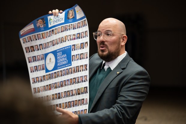 State Sen. Rodney Pol, D-Chesterton, holds up a poster of the 2023 Indiana General Assembly as he speaks to Chesterton High School students on Friday, December 8, 2023. (Kyle Telechan for the Post-Tribune)