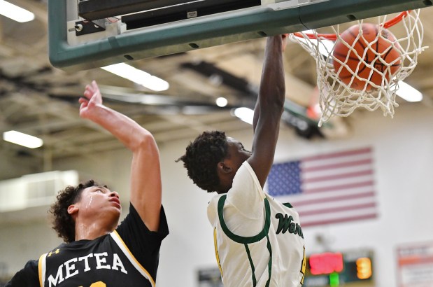 Waubonsie Valley's Moses Wilson (4) dunks the ball in front of Metea Valley's Will Ashford during a DuPage Valley Conference game in Aurora on Friday, Dec. 8, 2023.