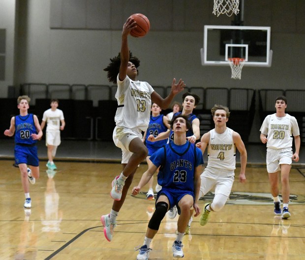 Grayslake North's Jayden Hunt (13) takes the ball to the basket against Highland Park's Nicholas Blumer (23) during a game in Grayslake on Wednesday, Dec. 7, 2022. (Michael Schmidt / for the Lake County News-Sun)