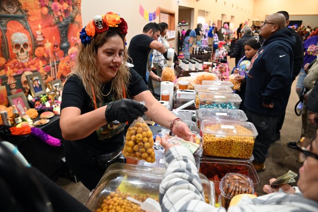 Left, vendor Dorisela Bahena of Round Lake Beach, and of La Casa de Doris of Round Lake Beach, waits on customers at the Village of Round Lake Beach Day of the Dead Celebration on Nov. 1, 2024 in Round Lake Beach. (Karie Angell Luc/Lake County News-Sun)