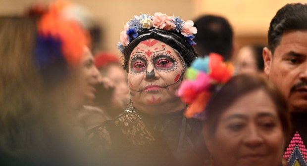 On left, waiting at the La Casa de Doris of Round Lake Beach food vendor table is, in traditional makeup, Maria Mascote of Grayslake at the Village of Round Lake Beach Day of the Dead Celebration on Nov. 1, 2024 in Round Lake Beach. (Karie Angell Luc/Lake County News-Sun)