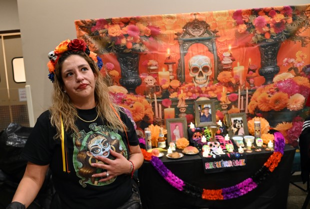 With emotion, vendor Dorisela Bahena of Round Lake Beach, and of La Casa de Doris of Round Lake Beach, recalls loved ones on the ofrenda or altar (on right) behind the vendor table at the Village of Round Lake Beach Day of the Dead Celebration on Nov. 1, 2024 in Round Lake Beach. (Karie Angell Luc/Lake County News-Sun)