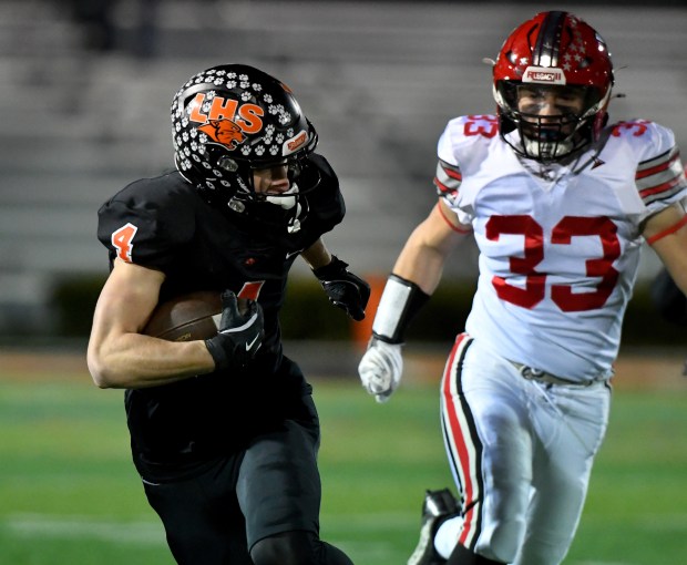 Libertyville's Blaise LaVista (4) runs past Deerfield's Nathan Margulis (33) on his way to scoring his first touchdown which was on Libertyville's first offensive play in the first quarter. Libertyville defeated Deerfield 43-10 in their game in the first round of the Class 6A playoffs in Libertyville on Friday, Nov. 1, 2024 (Rob Dicker / for the News-Sun)