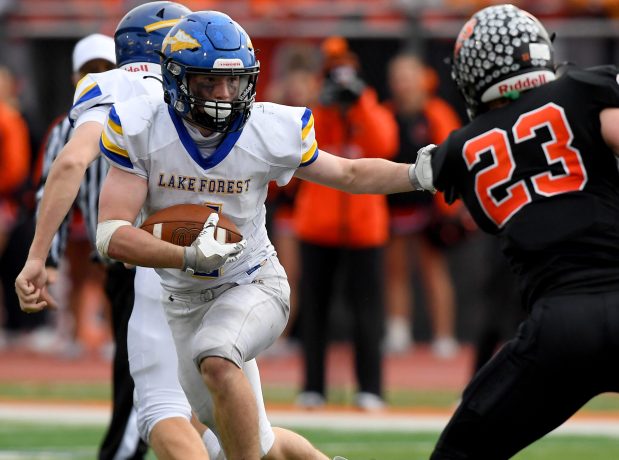 Lake Forest's Martin Hippel (4) runs the ball before her gets stopped by Libertyville's Caleb Baczek (23) and other defenders. Seventh ranked Lake Forest defeated second ranked Libertyville 23-17 at the football game in the second round of the Class 6A playoff football game in Libertyville on Saturday, Nov. 9, 2024 (Rob Dicker / for the News-Sun)