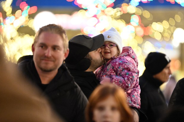 Taylor Joseph, 2, of Highland Park gets a kiss from her father Brad Joseph at the Holiday Lighting event at Port Clinton Square (600 Central Ave.) in downtown Highland Park on Nov. 23, 2024. (Karie Angell Luc/Lake County News-Sun)