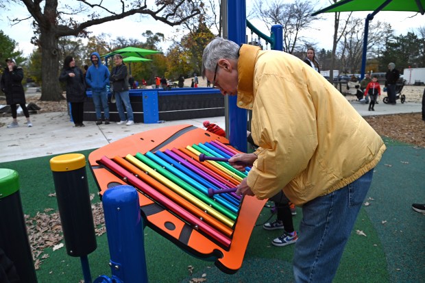 Trying the xylophone is Jim Clarke of Deerfield after the ribbon cutting ceremony at the renovated Jewett Park playground on Nov. 9, 2024 in Deerfield. (Karie Angell Luc/Lake County News Sun)