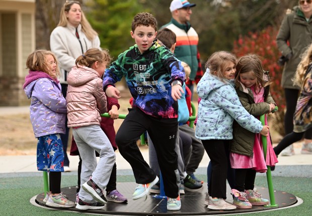 Jumping off the merry-go-round is Liam Marshall, almost 9, a third-grader of Deerfield after the ribbon cutting ceremony at the renovated Jewett Park playground on Nov. 9, 2024 in Deerfield. (Karie Angell Luc/Lake County News Sun)