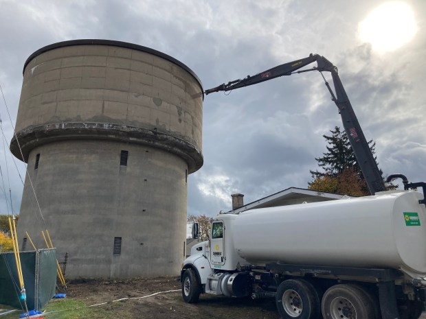 A giant jackhammer mounted on a construction crane punches a lone in the water tower. (Steve Sadin/For the Lake County News-Sun)