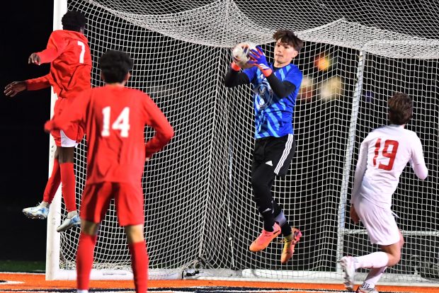 Naperville Central goalkeeper Connor Waite makes a save from a header attempt by West Aurora's Gentil Selemani (7) during the Class 3A Naperville North Sectional championship game on Friday, Nov. 1, 2024 in Naperville...(Jon Cunningham/for The Naperville Sun)