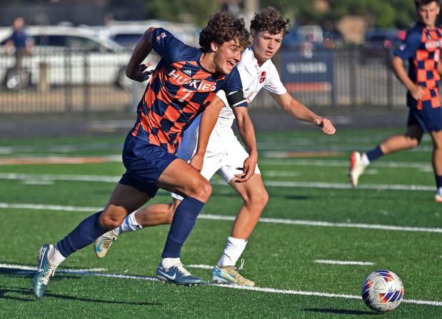 Naperville North's Noah Radeke dribbles the ball past Oswego's Dustin King. Naperville North defeated Oswego in a boys soccer game, 6-0, Tuesday, Sept. 3, 2024, in Naperville, Illinois.   (Jon Langham/for Naperville Sun)