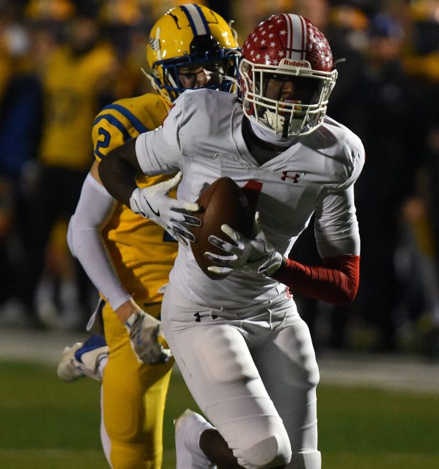 Naperville Central's DeShaun Williams (1) makes the catch against Lyons Township's Travis Stamm (2) and heads to the end zone for a touchdown and a 14-0 lead during the Class 8A state quarterfinal Friday, Nov. 15, 2024 in Western Springs, IL. (Steve Johnston/for the Naperville Sun)