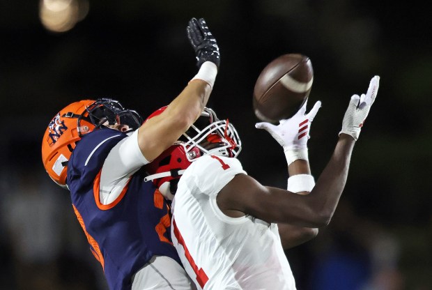 Naperville North's Zachary Mally (20) knocks a pass away from Naperville Central's DeShaun Williams (1) in the second quarter during an DuPage Valley Conference game at North Central College on Friday, Sept. 6, 2024. (H. Rick Bamman / Naperville Sun)