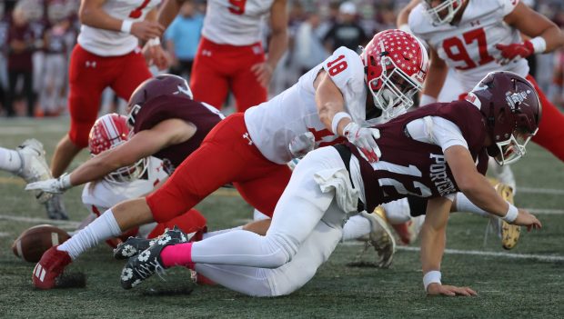 Naperville Central's Gavin Wade (18) tackles Lockport quarterback Brendan Mecher (12) on a fumble during a game in Lockport on Friday, Oct. 4, 2024. (Talia Sprague / Naperville Sun)