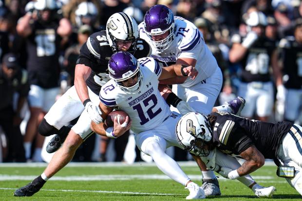 Northwestern quarterback Jack Lausch is tackled by Purdue defensive back Antonio Stevens during the first half in West Lafayette, Ind., on Nov. 2, 2024. (AP Photo/Michael Conroy)