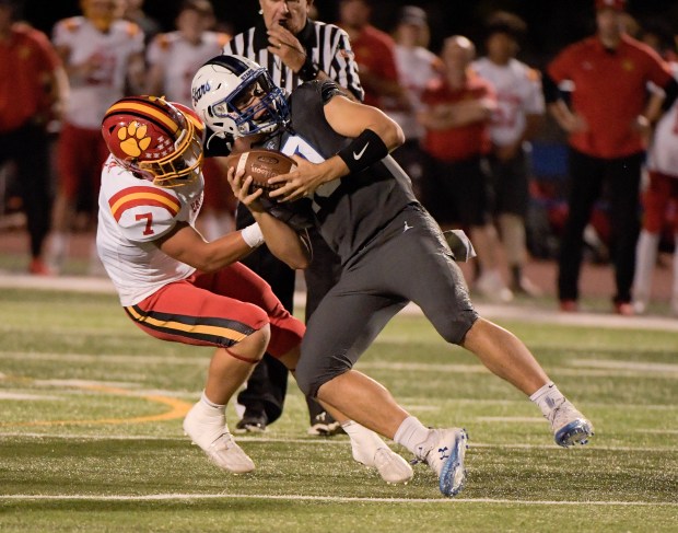 Batavia's RJ Bohr (7) sacks St. Charles North quarterback Ethan Plumb (10) during a DuKane Conference game in St. Charles on Friday, Sept. 15, 2023.