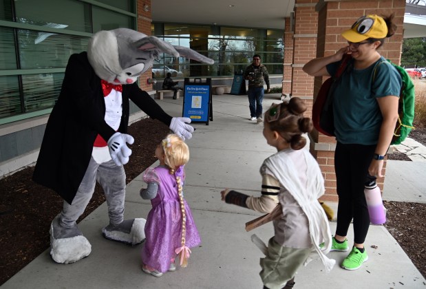 From left, Bugs Bunny welcomes Dahlia James, 2, of Long Grove and Dahlia's sibling Melody, 5, a kindergartner. The children's parent Rebecca James is on right at the Mini Comic Con at the Vernon Area Public Library on Nov. 16, 2024 in Lincolnshire (Karie Angell Luc/Pioneer Press)