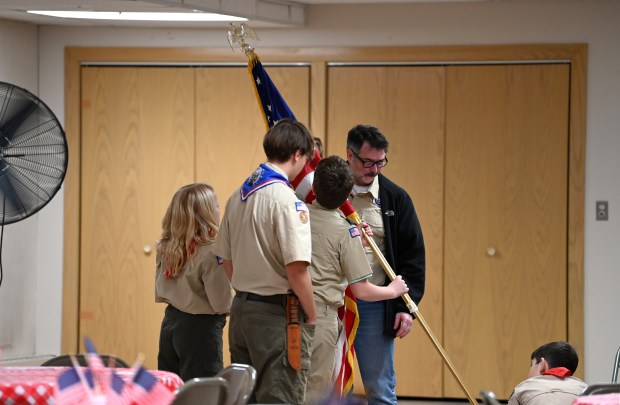 Boy Scout Troop 21 of Barrington sets the American flag on its pedestal at Saint Matthew Lutheran Church (720 Dundee Ave.) at The Community Meal in Barrington on Nov. 12, 2024, the Tuesday evening after Veterans Day. (Karie Angell Luc/Pioneer Press)