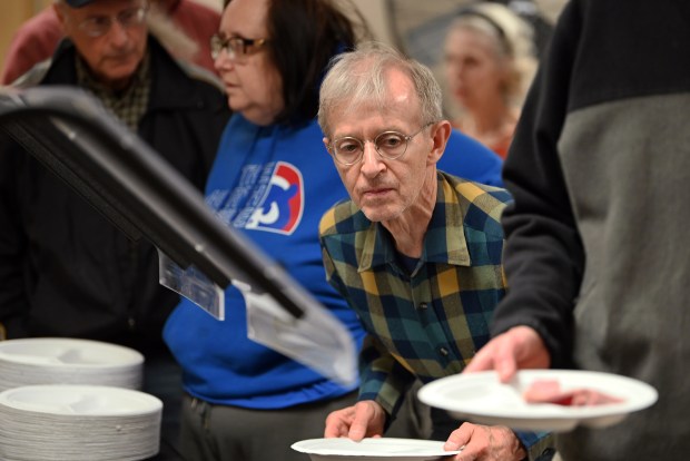 Dan Nieves of Barrington, center, is at the buffet line at Saint Matthew Lutheran Church (720 Dundee Ave.) before meal service at The Community Meal in Barrington on Nov. 12, 2024, the Tuesday evening after Veterans Day. (Karie Angell Luc/Pioneer Press)