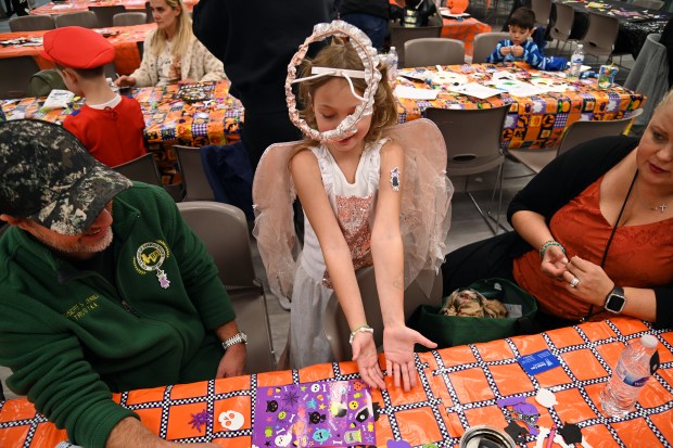 Wearing the angel halo is Siena Zerillo, 8, a third-grader from Harwood Heights. On left is Siena's parent Giuseppe S. Zerillo, Harwood Heights village trustee, at the Harwood Heights Youth Commission Halloween Party on Oct. 26, 2024 at the Harwood Heights Recreation Center in Harwood Heights. (Karie Angell Luc/Pioneer Press)