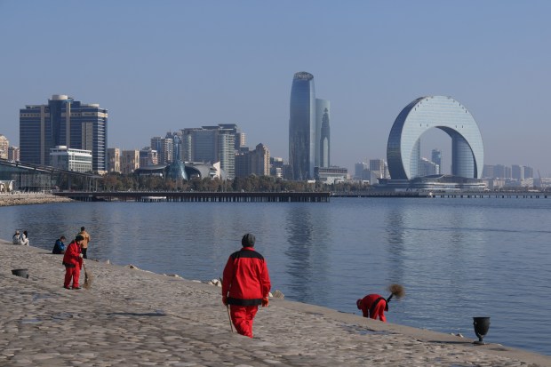 Workers sweep along the shore of the Caspian Sea as modern office towers stand behind one day before the opening of the UNFCCC COP29 Climate Conference on Nov. 10, 2024 in Baku, Azerbaijan. A contingent of area high school students will be on hand for the conference. (Sean Gallup/Getty Images)