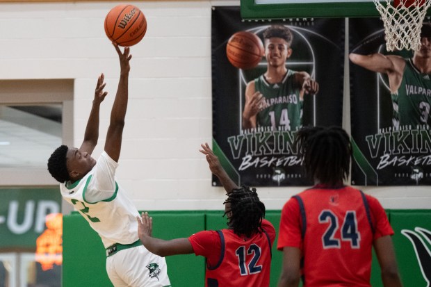 Valparaiso's KJ Avery, left, puts up a shot over East Chicago Central's Marquice Winters, center, during a game in Valparaiso on Friday, Dec. 1, 2023. (Kyle Telechan for the Post-Tribune)